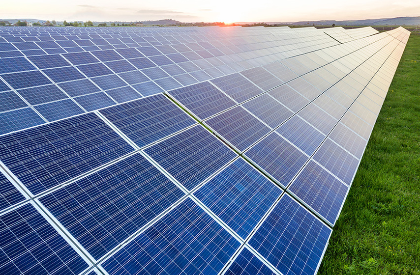 Blue solar photo voltaic panels system producing renewable clean energy rural landscape setting sun background